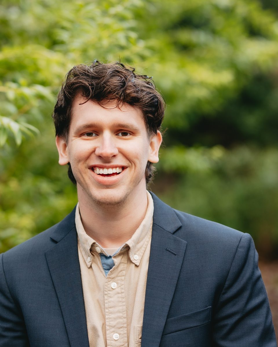 Caleb Grimes, smiling, in a navy blazer outdoors